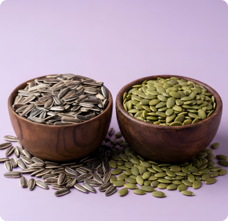 Two wooden bowls filled with sunflower seeds and pumpkin seeds on a light purple background