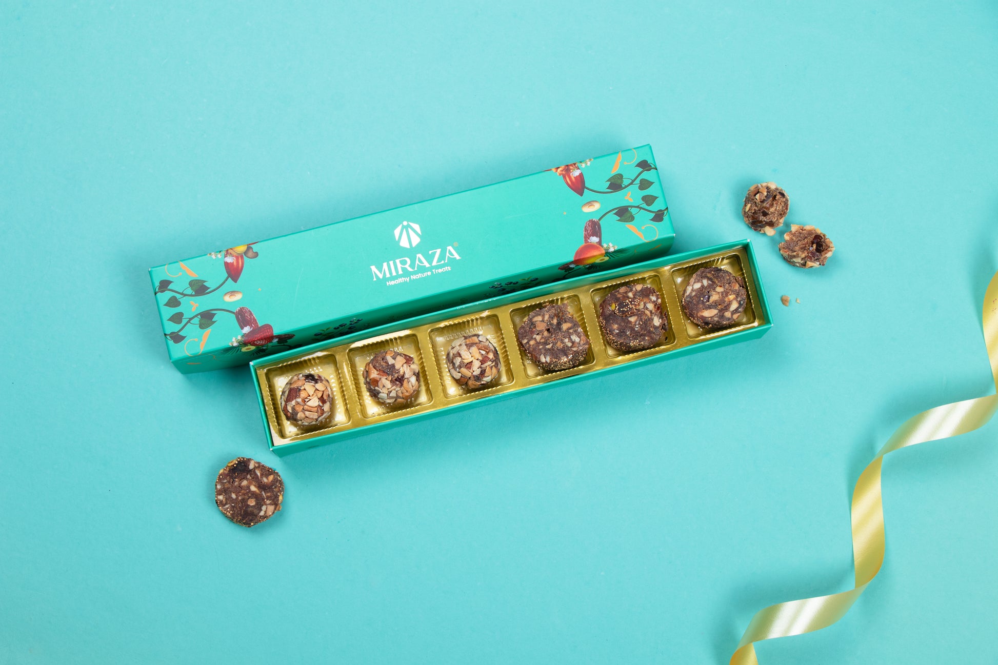 Box of Miraza chocolates on a blue background with gold ribbon